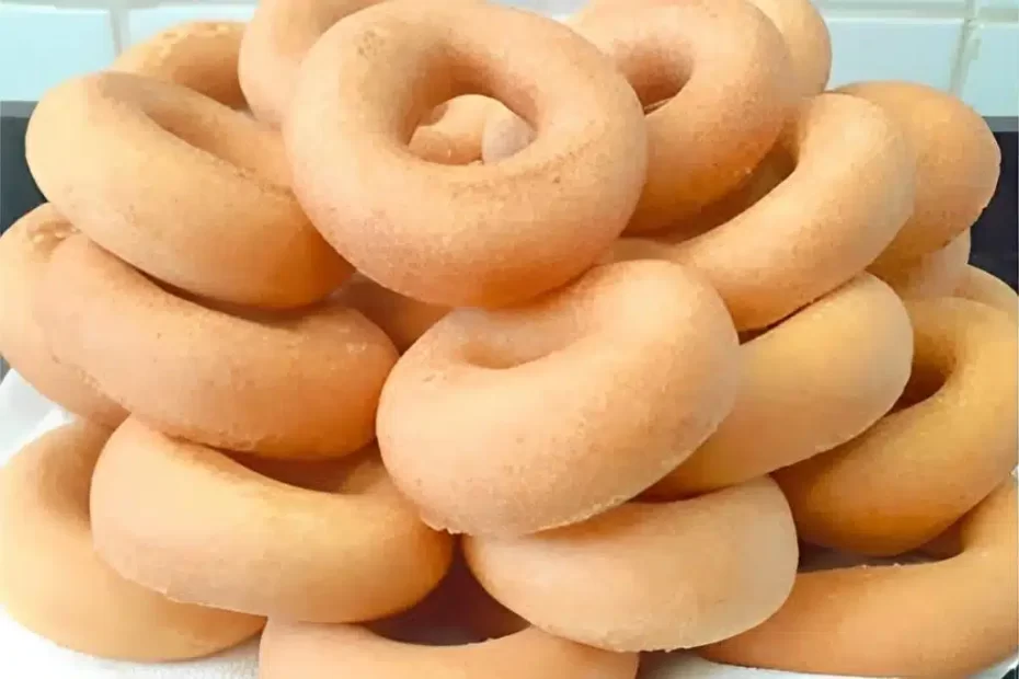 Uma rosquinha de polvilho leve e fofinha servida com uma xícara de café.